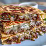 Golden, crispy flour tortillas stuffed with two thin smashburger patties, draped in a punchy mayo-mustard sauce for a savory bite.