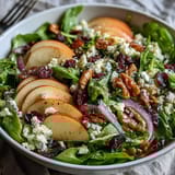 Sliced apples and tangy cider vinaigrette bring bright flavor to this vibrant vegetarian salad bowl.