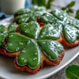 Shamrock-shaped sugar cookies decorated with bright green royal icing, perfect for St. Patrick's Day celebrations and festive dessert tables.