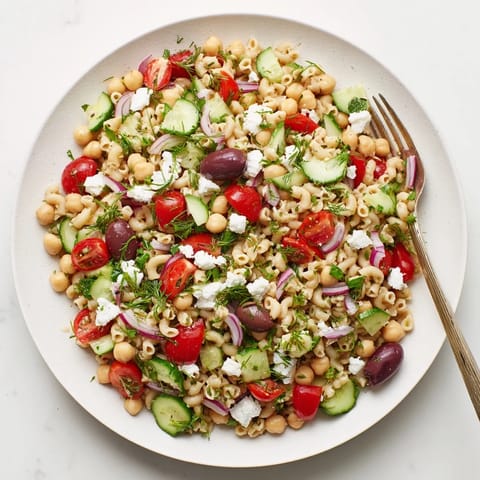Bright Lemon Herb Chickpea Pasta Salad served chilled, featuring chickpea pasta, crisp vegetables, and crumbled feta for a refreshing light lunch or picnic side.