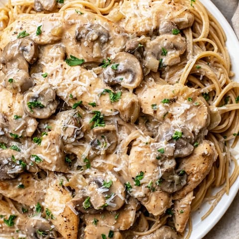 Golden chicken strips rest atop skinny spaghettini tossed with sautéed mushrooms in a creamy, Parmesan-kissed sauce.
