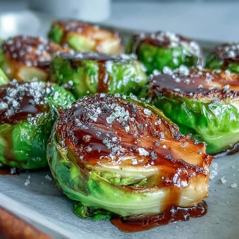 Freshly roasted Brussels sprouts glistening with tangy balsamic glaze, paired with sliced turkey for a complete holiday meal.
