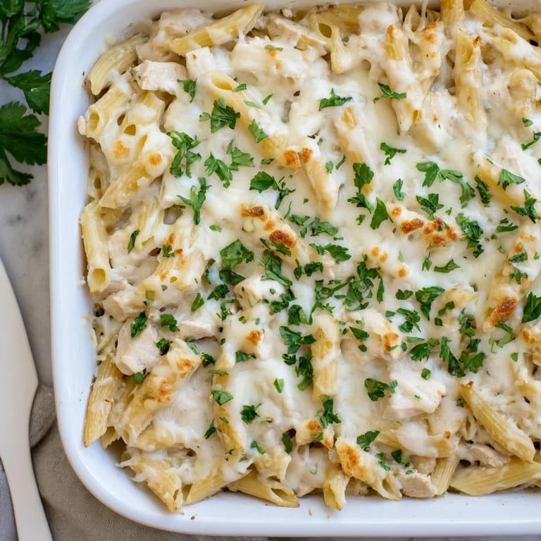 Creamy Chicken Alfredo Bake with penne pasta and tender chicken cubes inside.