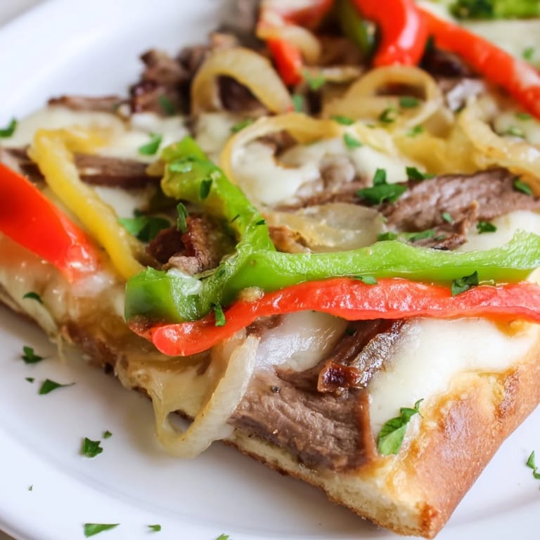 Homemade Philly Cheesesteak Pizza served hot on a wooden cutting board, ready to be sliced for a family dinner.