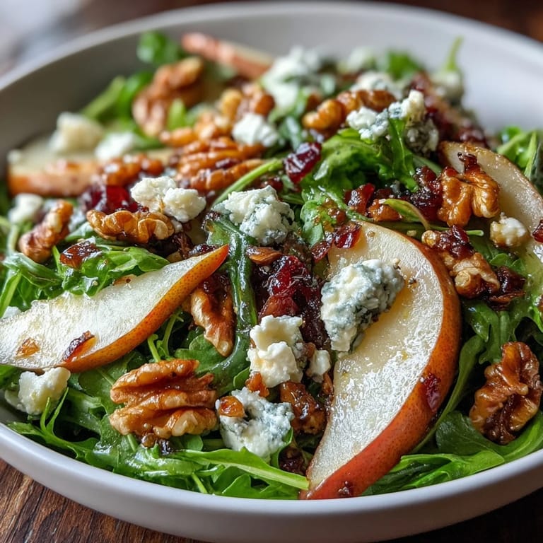 Sliced ripe pears and peppery arugula in a vibrant Arugula and Pear Bowl with balsamic drizzle.