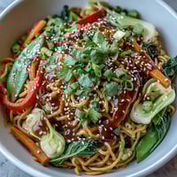 Vibrant stir-fried Shirataki Noodle Bowl with crisp veggies, toasted sesame seeds, and fresh cilantro garnish.