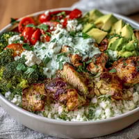 Freshly sautéed cauliflower rice base topped with seasoned chicken, crisp bell peppers, and vibrant broccoli florets.