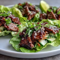 Korean BBQ Beef Lettuce Wraps: tender steak, crisp lettuce, flavorful kimchi topping joy.