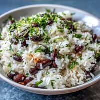 Vibrant coconut lime rice with cilantro and black beans, steaming hot and fluffy.